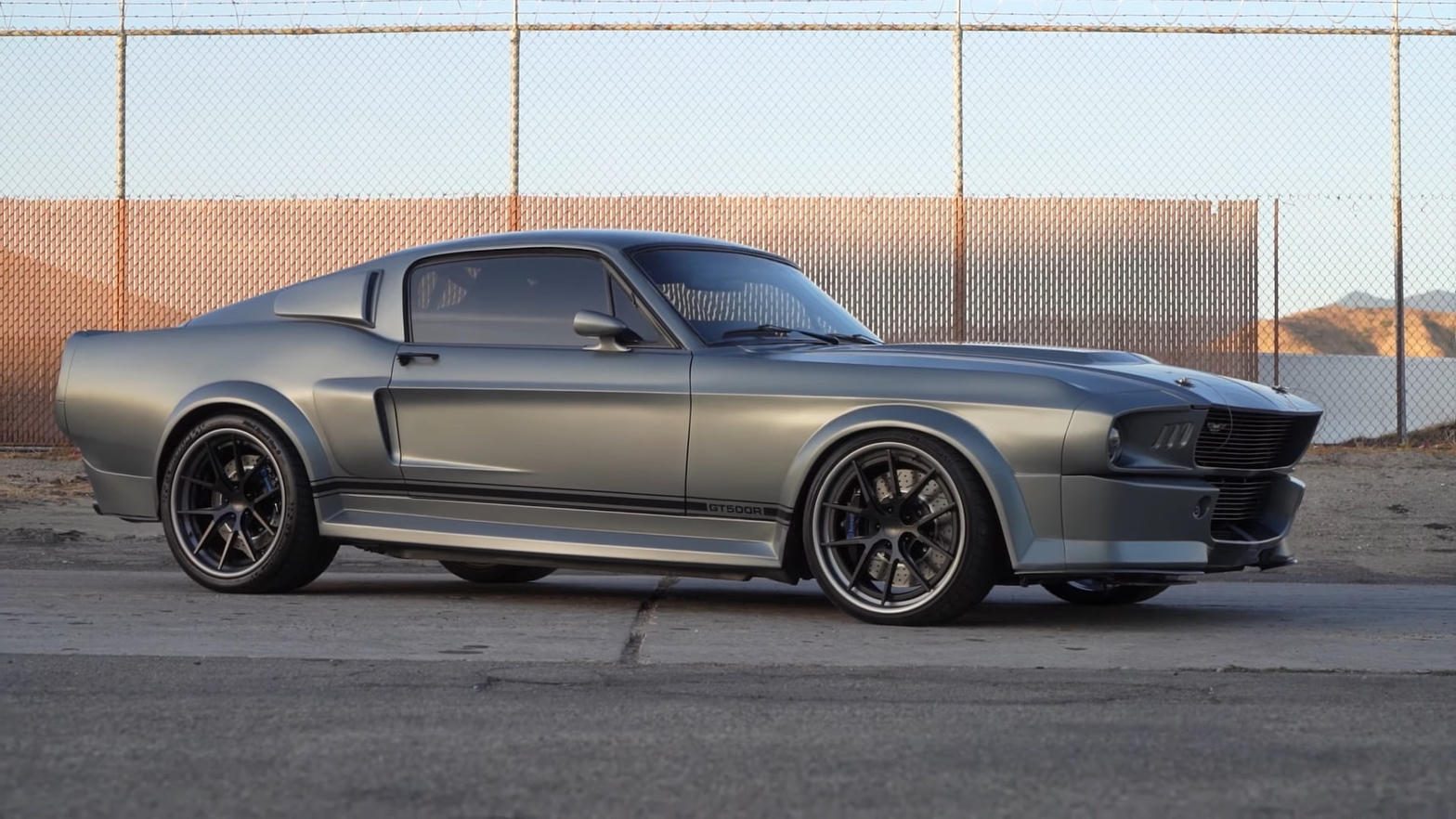 Silver MAGStang GT500R side profile against a chain-link fence